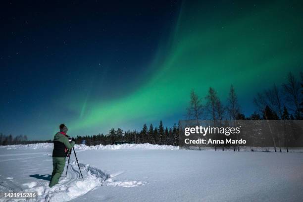 women photographing the northern lights in finland. - rovaniemi stock pictures, royalty-free photos & images