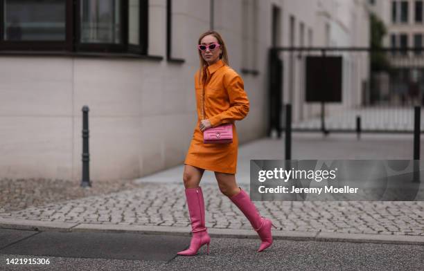 Sonia Lyson is seen wearing pink Chiara Ferragni shades, orange Remain leather mini dress, Jimmy Choo pink leather Dreece Knee Boot 95 and Jimmy Choo...