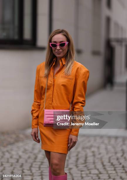 Sonia Lyson is seen wearing pink Chiara Ferragni shades, orange Remain leather mini dress and Jimmy Choo Varenne Avenue pink leather clutch bag,...