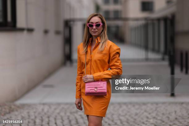 Sonia Lyson is seen wearing pink Chiara Ferragni shades, orange Remain leather mini dress and Jimmy Choo Varenne Avenue pink leather clutch bag,...