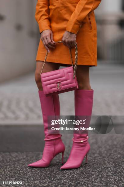 Sonia Lyson is seen wearing orange Remain leather mini dress, Jimmy Choo pink leather Dreece Knee Boot 95 and Jimmy Choo Varenne Avenue pink leather...