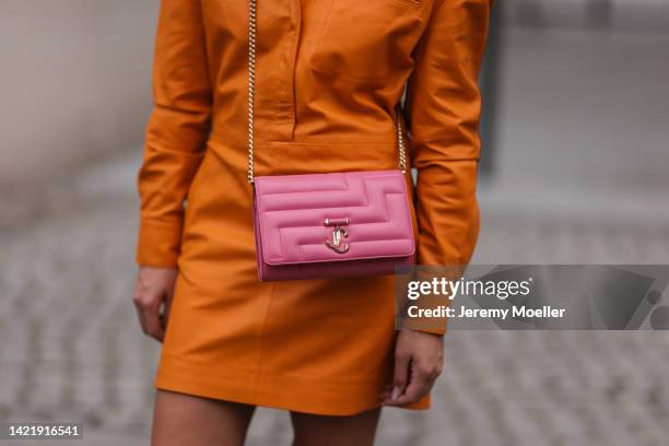 Sonia Lyson is seen wearing orange Remain leather mini dress and Jimmy Choo Varenne Avenue pink leather clutch bag, during Berlin Fashion Week...