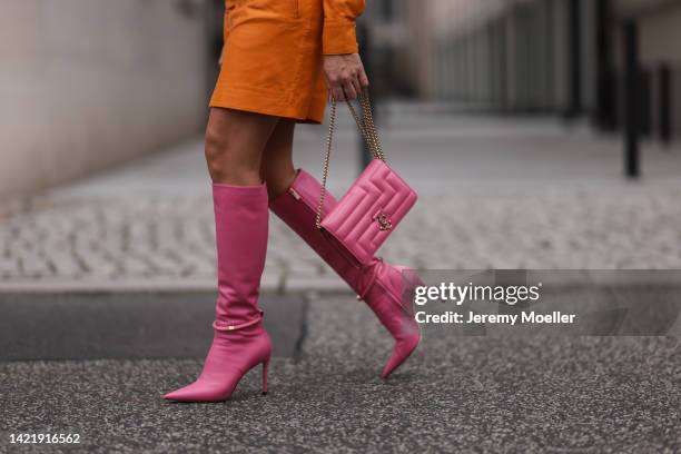 Sonia Lyson is seen wearing orange Remain leather mini dress, Jimmy Choo pink leather Dreece Knee Boot 95 and Jimmy Choo Varenne Avenue pink leather...