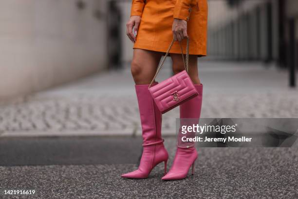 Sonia Lyson is seen wearing orange Remain leather mini dress, Jimmy Choo pink leather Dreece Knee Boot 95 and Jimmy Choo Varenne Avenue pink leather...