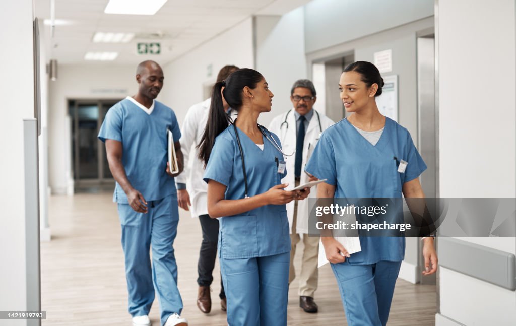 Doctor, nurse and walking hospital team after success surgery, medicine meeting or clinic insurance planning. Diversity workers, smile and happy medical healthcare teamwork on treatment collaboration