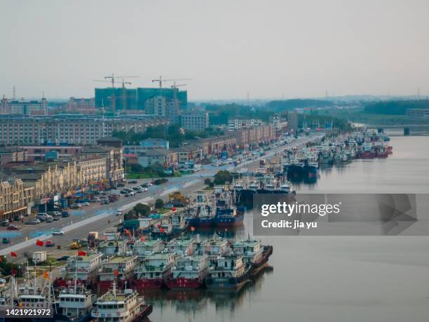 nantong rudong county, yangkou port fishing boat wharf, a large number of fishing boats docked on the shore. nantong city, jiangsu province, china. - nantong stock-fotos und bilder