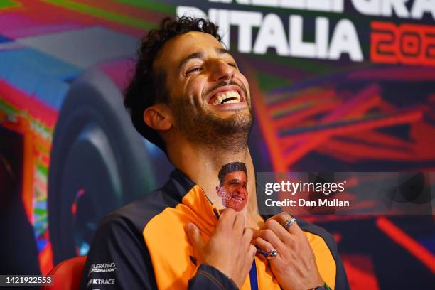 Daniel Ricciardo of Australia and McLaren shows a fake tattoo of Lando Norris of Great Britain and McLaren on his neck during the drivers press...