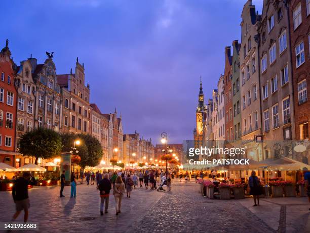 tourists and residents stroll along dlugi targ street at dusk. - gdansk stock pictures, royalty-free photos & images