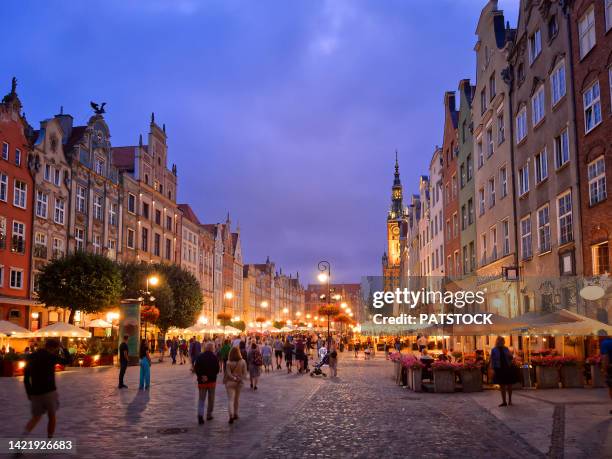 tourists and residents stroll along dlugi targ street at dusk. - gdansk poland stock pictures, royalty-free photos & images