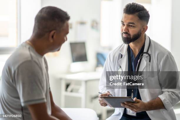 male doctor talking with a patient - males stock pictures, royalty-free photos & images