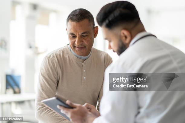 reviewing test results with the doctor - general practitioner stock pictures, royalty-free photos & images