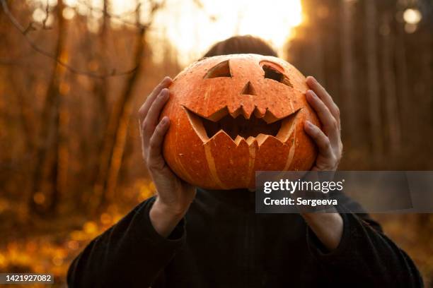un jeune homme et jack o' lantern - halloween photos et images de collection