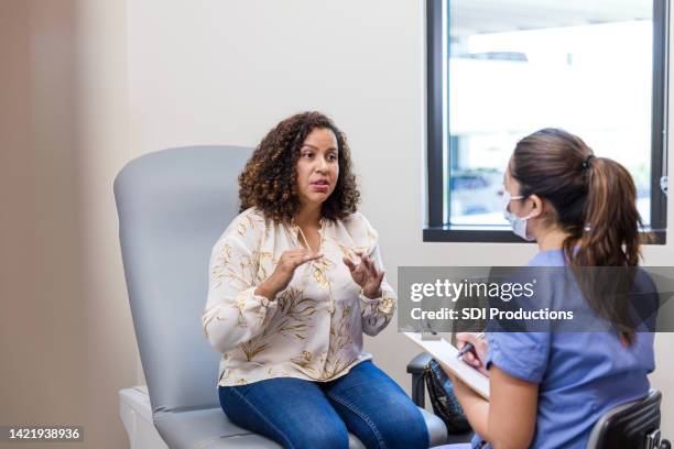 adult patient gestures while talking to the nurse - vrouwenkwesties stockfoto's en -beelden