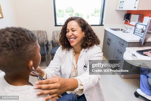 unrecognizable boy and female doctor enjoy using stethoscope - showing empathy stock pictures, royalty-free photos & images