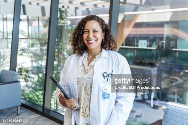 female doctor smiles for hospital publicity photo - clean suit stock pictures, royalty-free photos & images