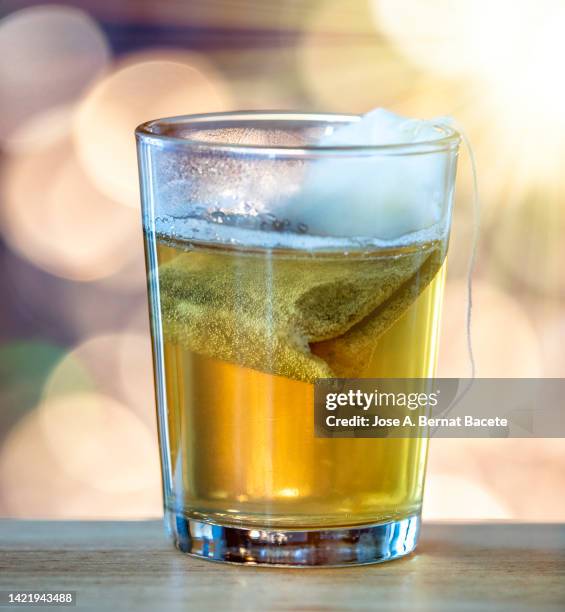 glass cup with a hot infusion of herbs illuminated by sunlight. - sachet stockfoto's en -beelden