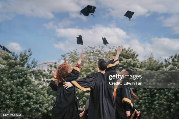 excited asian students tossing mortarboard in the air on graduation day tradition - malaysia school stock pictures, royalty-free photos & images