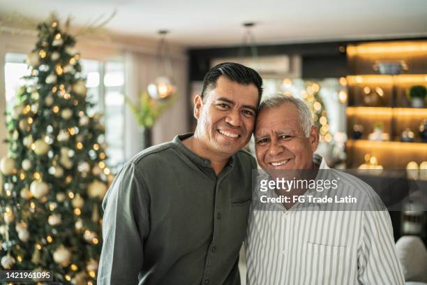 porträt von vater und sohn an weihnachten zu hause - latin father and son stock-fotos und bilder