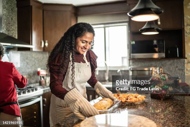 mid adult woman putting tenderloin with fruit on kitchen counter at home - apron gloves stock pictures, royalty-free photos & images