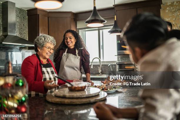 madre e hija preparando comida para la familia en la cocina de casa - christmas family fotografías e imágenes de stock