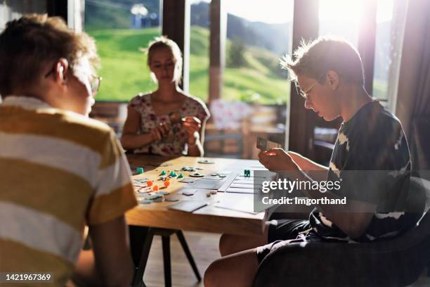 family playing large modern board game together at home - bordspel stockfoto's en -beelden