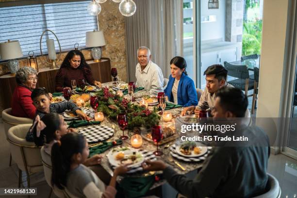 familiengespräch am esstisch zu weihnachten zu hause - familie zuhause essen stock-fotos und bilder