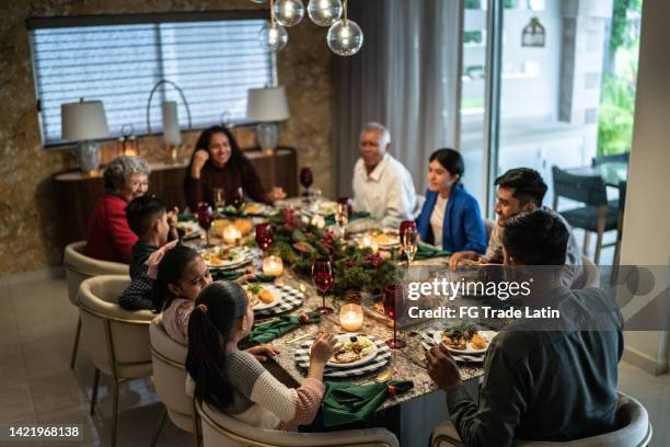 family talking in the dinner table on christmas at home - mexican christmas stock pictures, royalty-free photos & images