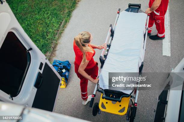 paramedics providing first aid to older man  injured  in accident - victim services stock pictures, royalty-free photos & images