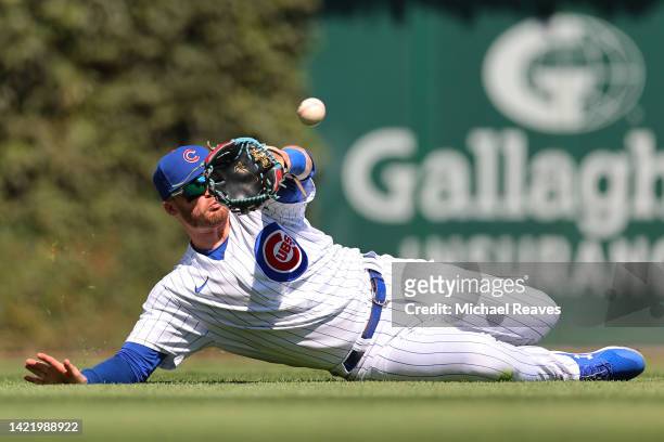 Ian Happ of the Chicago Cubs makes a diving catch on a ball hit by Jose Barrero of the Cincinnati Reds during the third inning at Wrigley Field on...