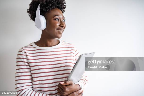 portrait of a confident, successful, happy young woman - headphones white background stock pictures, royalty-free photos & images