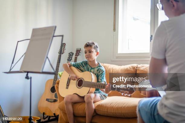 junge, der in der musikschule gitarre übt - private school education stock-fotos und bilder