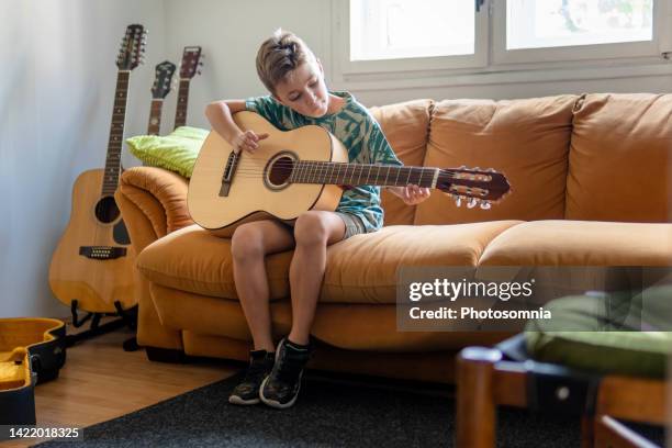 boy playing acoustic guitar - classical guitarist stock pictures, royalty-free photos & images