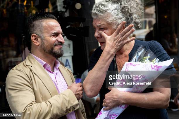 Nicky Perry, owner of Tea and Sympathy, and A Salt and Battery, wipes a tear from her face after Jono Manielle, from New York, gives her flowers...