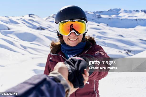 happy woman enjoying with her husband a sunny winter day in the alps between snowy mountains and adrenaline. - helmet stock pictures, royalty-free photos & images