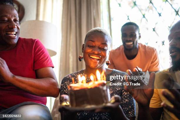 family celebrating young woman's birthday - birthday party friends stock pictures, royalty-free photos & images