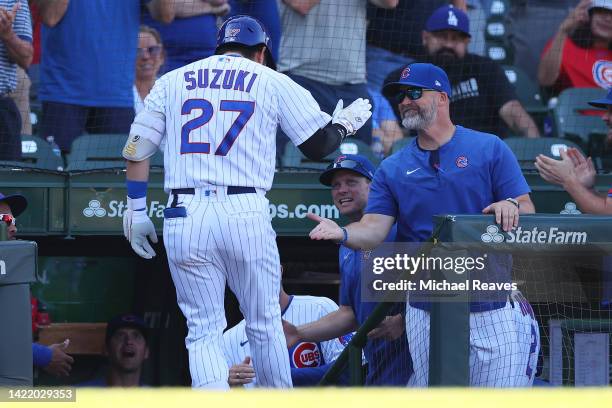 Seiya Suzuki of the Chicago Cubs high fives manager David Ross after hitting a solo home run against the Cincinnati Reds during the eighth inning at...