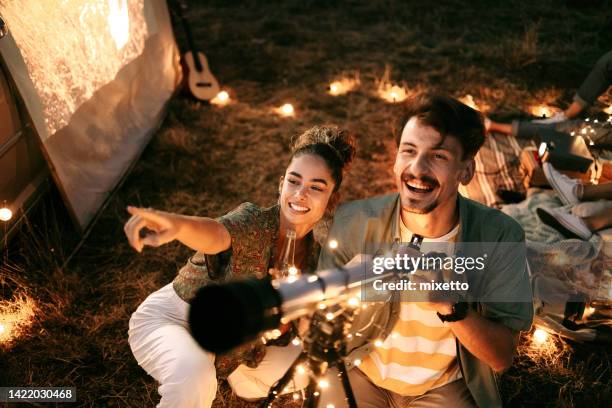 couple stargazing together with a astronomical telescope - astronomy imagens e fotografias de stock