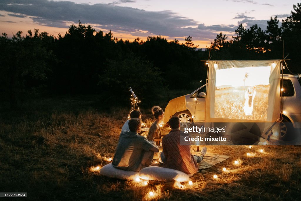 Gruppe von Freunden, die den Filmabend im Freien in der Natur genießen