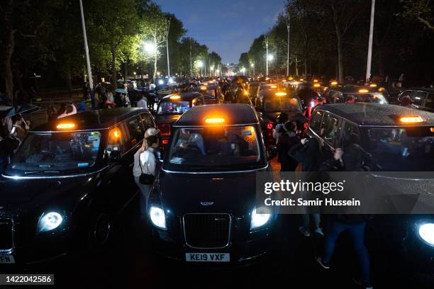 London black cabs lining The Mall leading up to Buckingham Palace to silently pay tribute to Queen Elizabeth II on September 08, 2022 in London,...