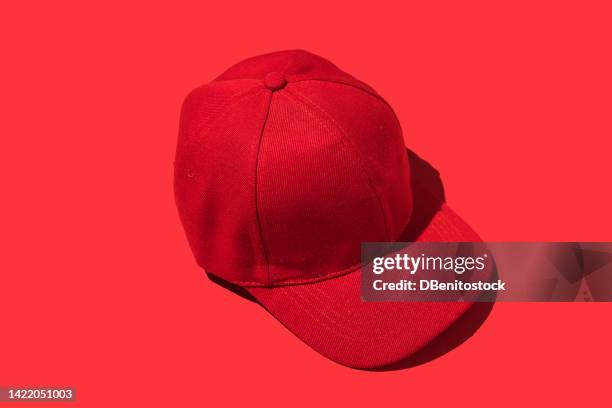 red baseball cap, on red background. concept of fashion, clothing, accessories, hip hop, baseball, sport, uniform and sun protection. - thread sewing item stock-fotos und bilder