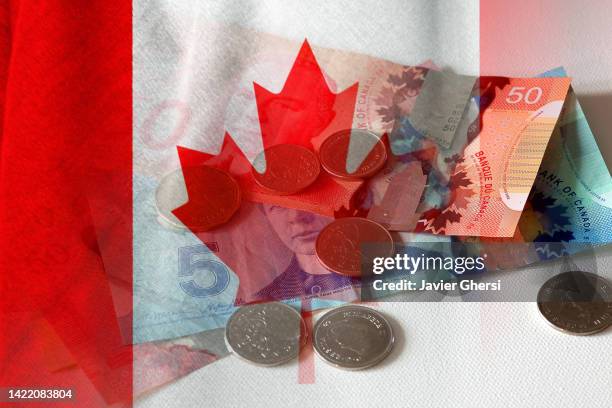 canadian dollar cash bills and coins and flag of canada - canada fotografías e imágenes de stock