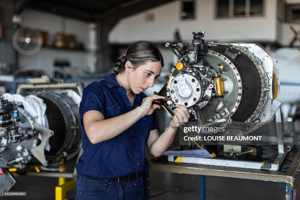 職場での実生活の若い女性航空機エンジニア見習い