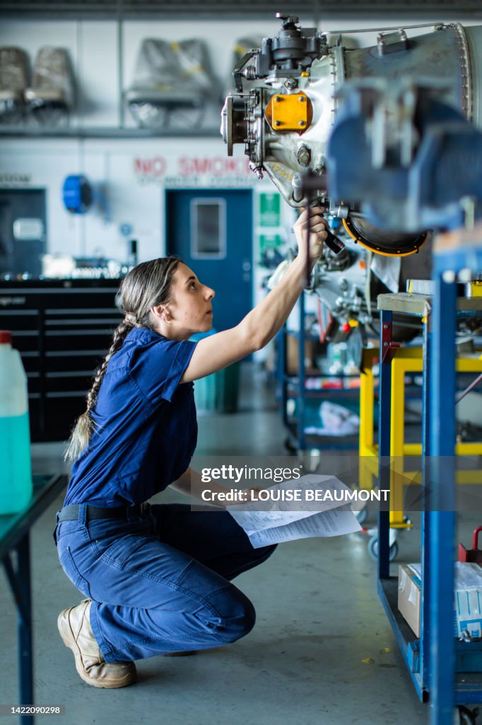 Real life young female aircraft engineer apprentice at work