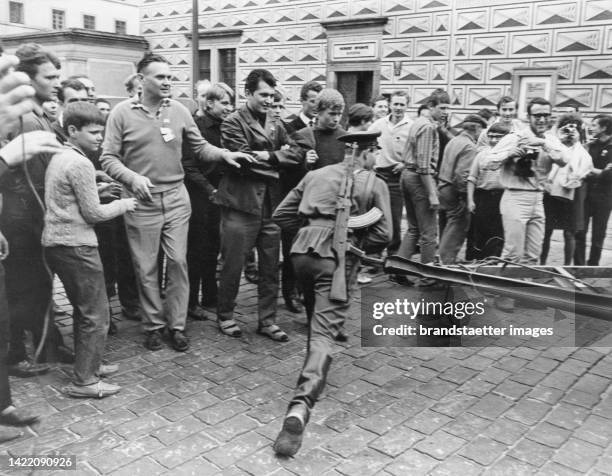 Residents of Prague watch a Russian soldier. Prague. 28 August 1968. Photographs.