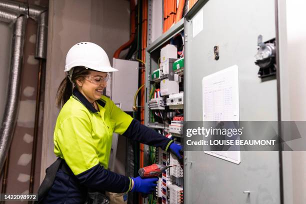 real life female electrician at work - electrical switchboard stock pictures, royalty-free photos & images