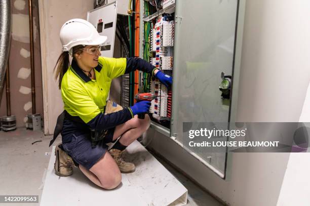 echte elektrikerin bei der arbeit - electromonteur stock-fotos und bilder