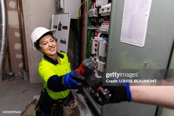 echte elektrikerin bei der arbeit - schaltschrank stock-fotos und bilder