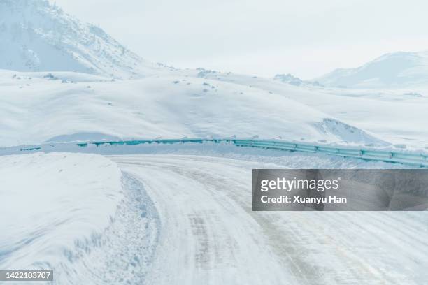 winter snow curved road - snow covered road stockfoto's en -beelden
