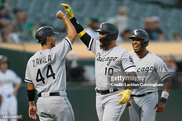 Yoan Moncada of the Chicago White Sox celebrates with Seby Zavala and Elvis Andrus after hitting a three-run home run in the top of the second inning...