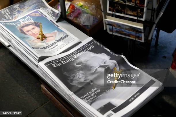 Miniature Eiffel Tower is placed on the front pages of newspapers, Daily Mail and the Daily Telegraph in a newsstand with the photos of Queen...